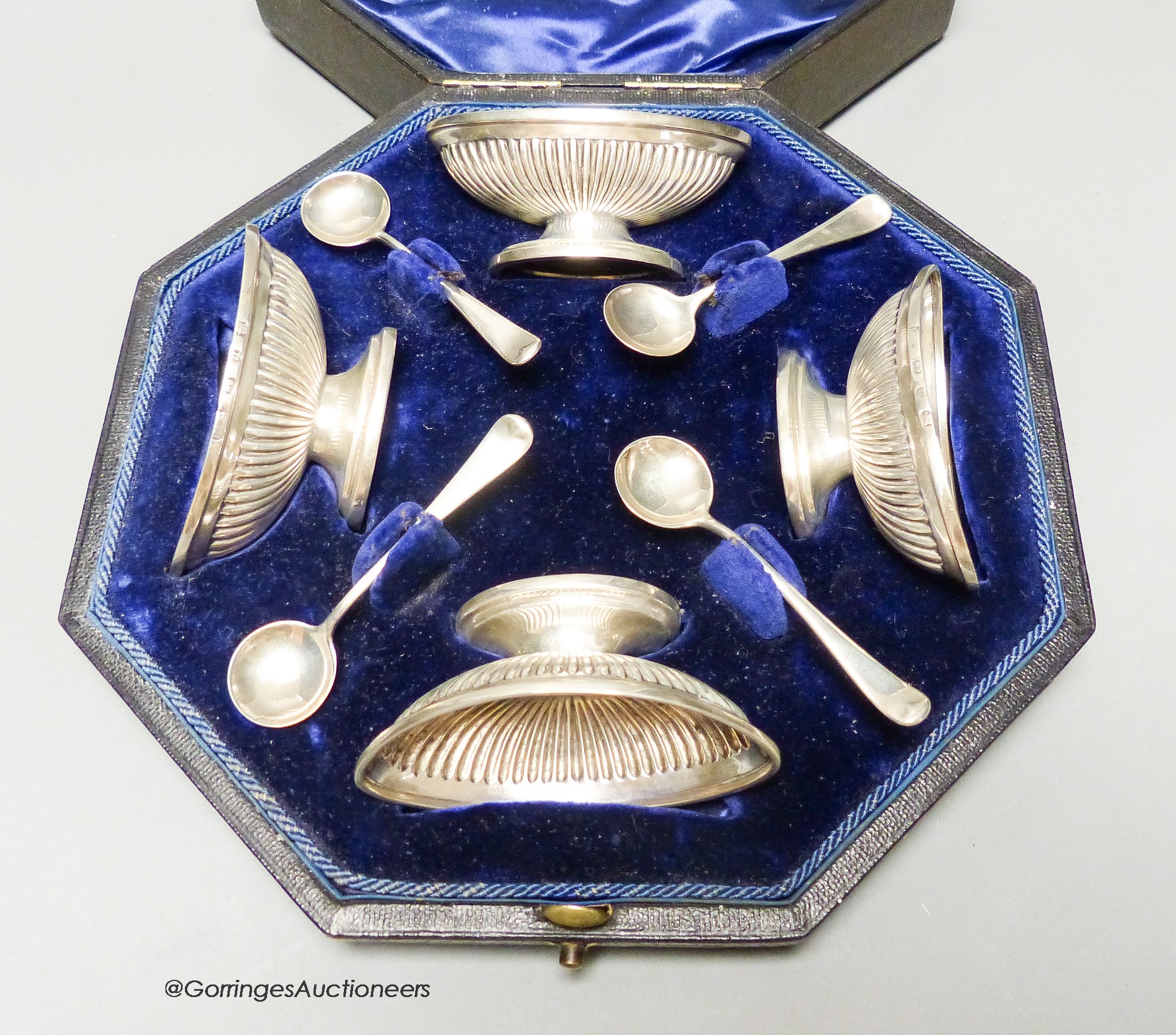 A cased set of four late Victorian fluted oval silver salts and four matching spoons, Elkington & Co, Birmingham, 1894.